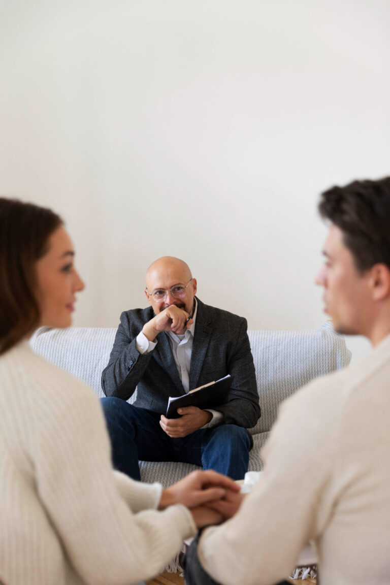 Adult couple seated together speaking with a counselor