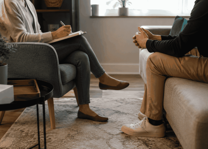 Therapy vs. Rehab for Addiction Substance abuse counselor and client having a private therapy session in a comfortable counseling office