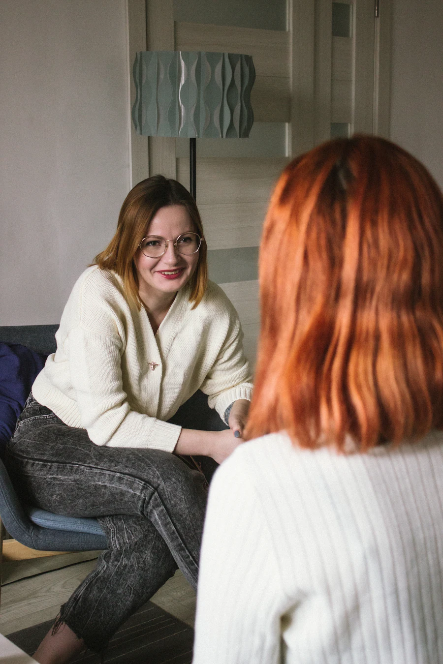 Two adult women talking face to face in a seating area